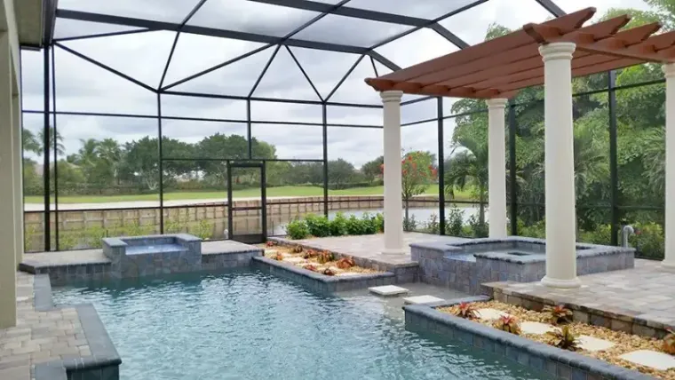 A screened lanai with a raised spa and pergola