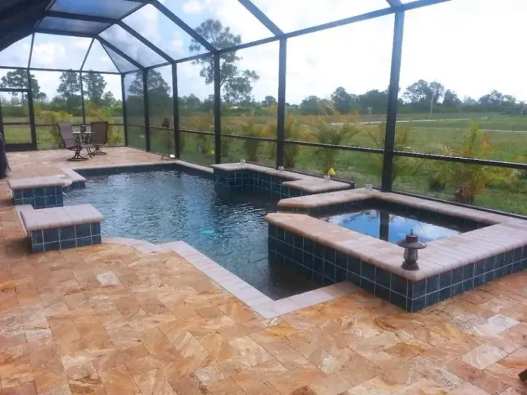 Screened swimming pool with a tan travertine deck built by Craig's Pacific Pools