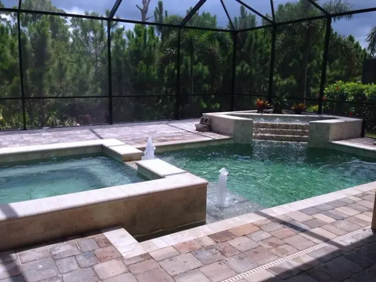 A raised spa with a tiled waterfall into the pool
