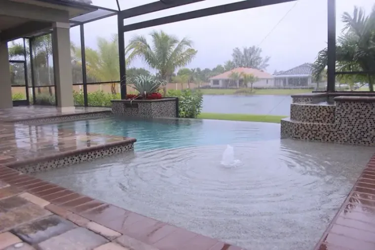 Infinity-edge pool looking out over a lake on an overcast Cape Coral afternoon