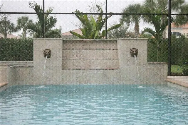 A twin lion-head bronze fountain feeding the pool